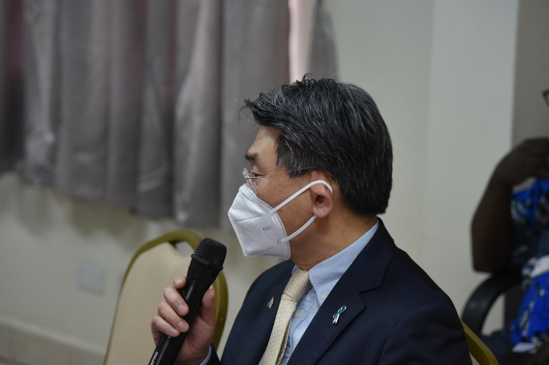 Man in a suit with a mask holding a microphone