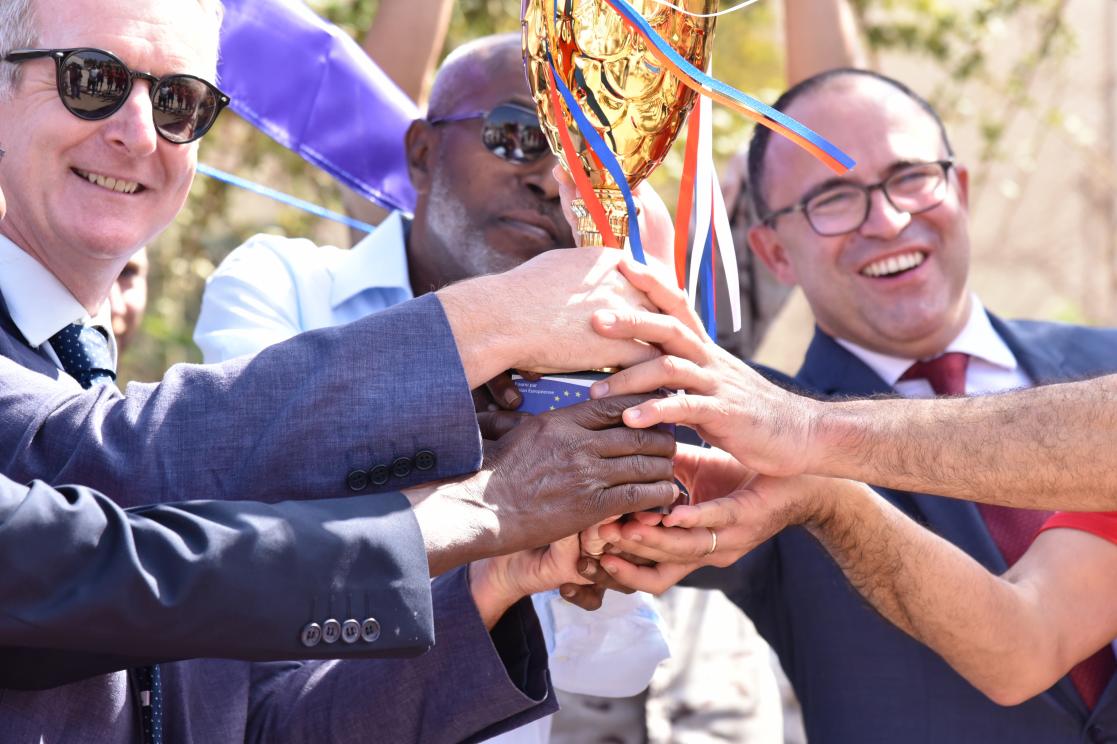 Three men holding a trophy