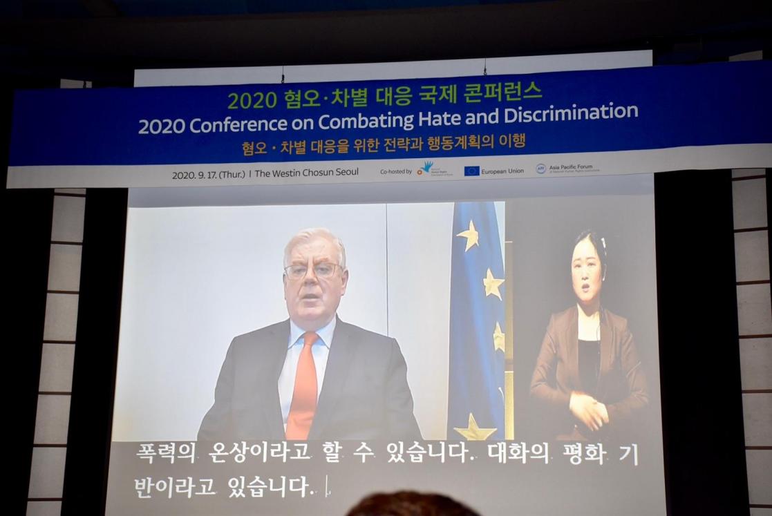 Video in a screen of a Man talking and a girl making the traduction 2020 Conference on Combating Hate and Discrimination