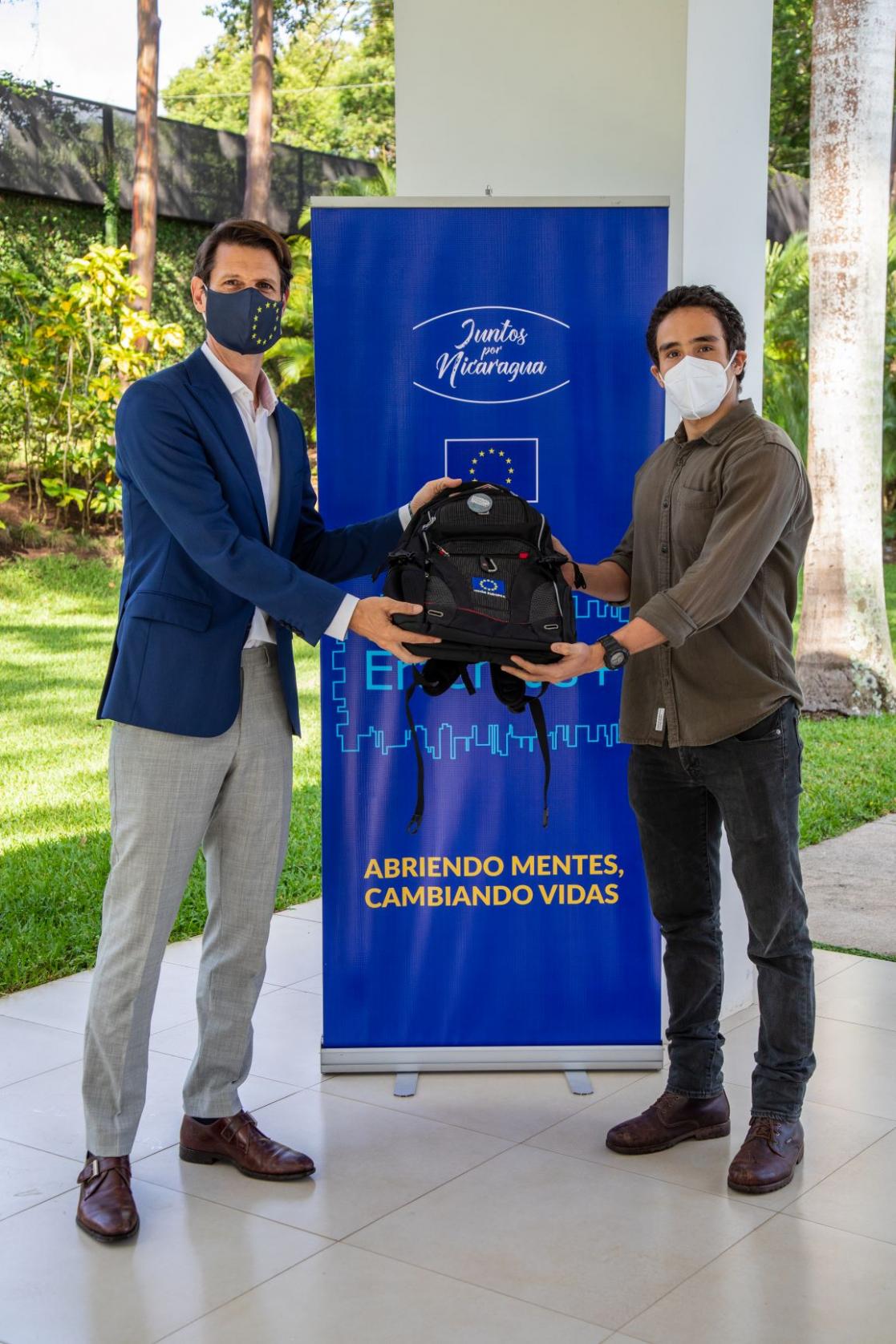 Two men holding a backpack