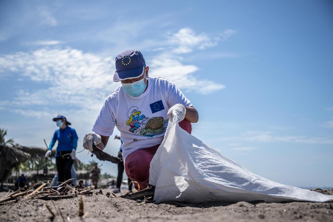 Volunteer picking up litter on the beach