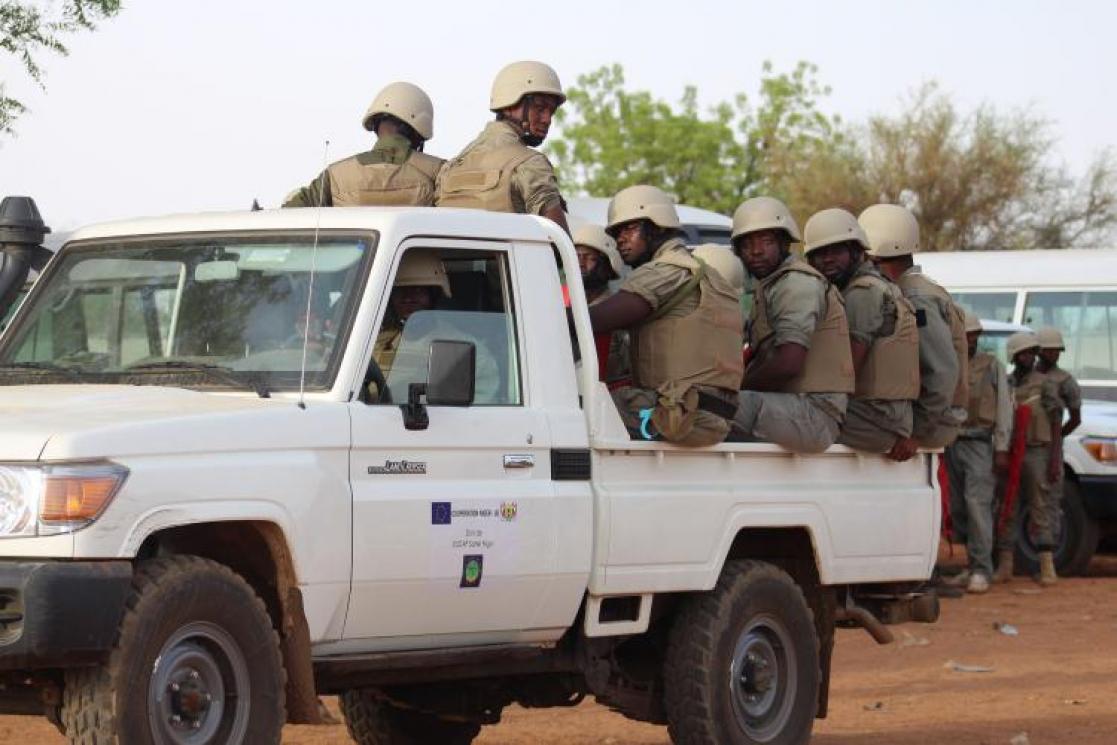 Military personnel riding in the back of a car