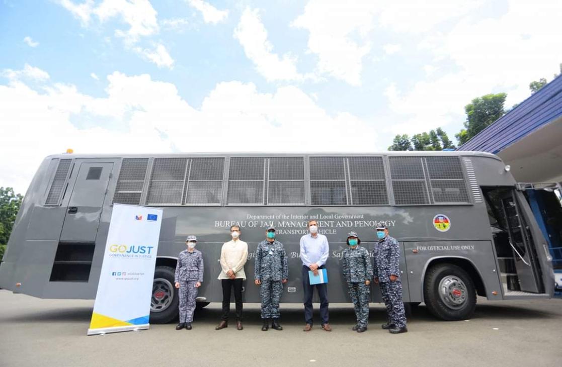 group of people posing in front of a bus 