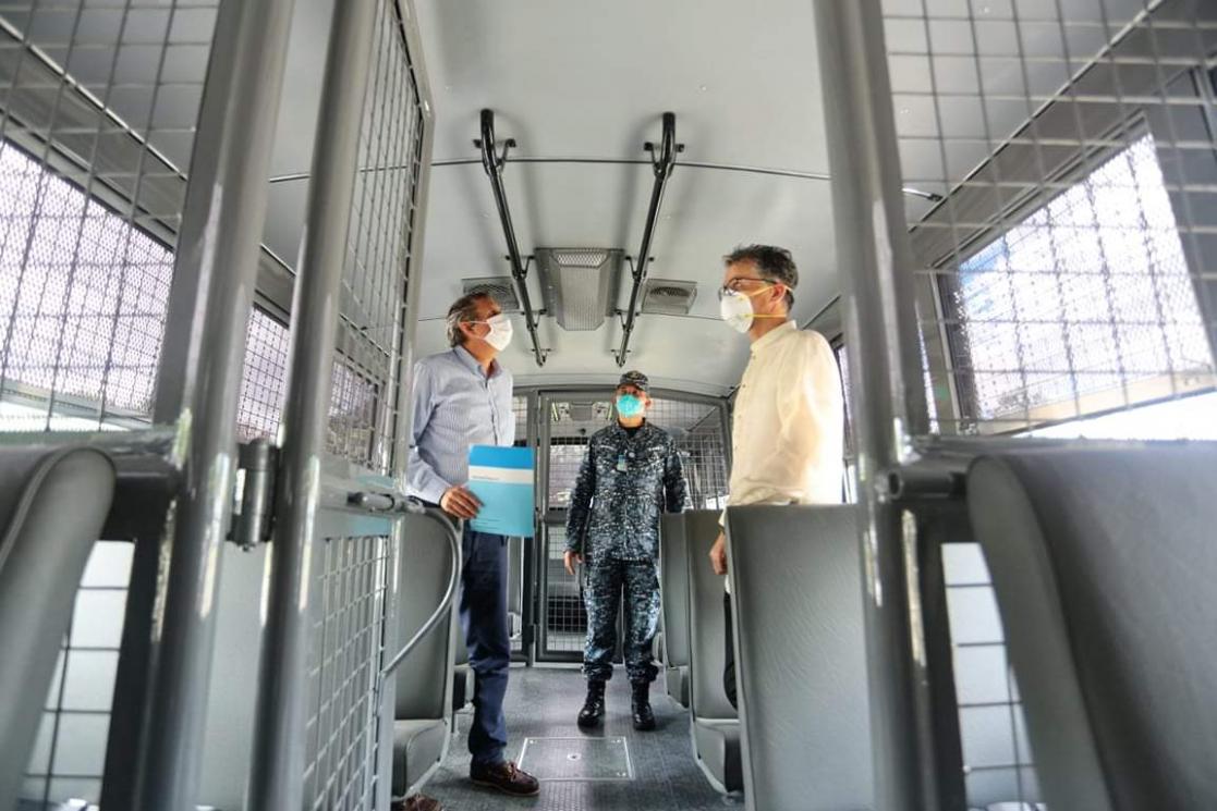 Three people inside a bus with security