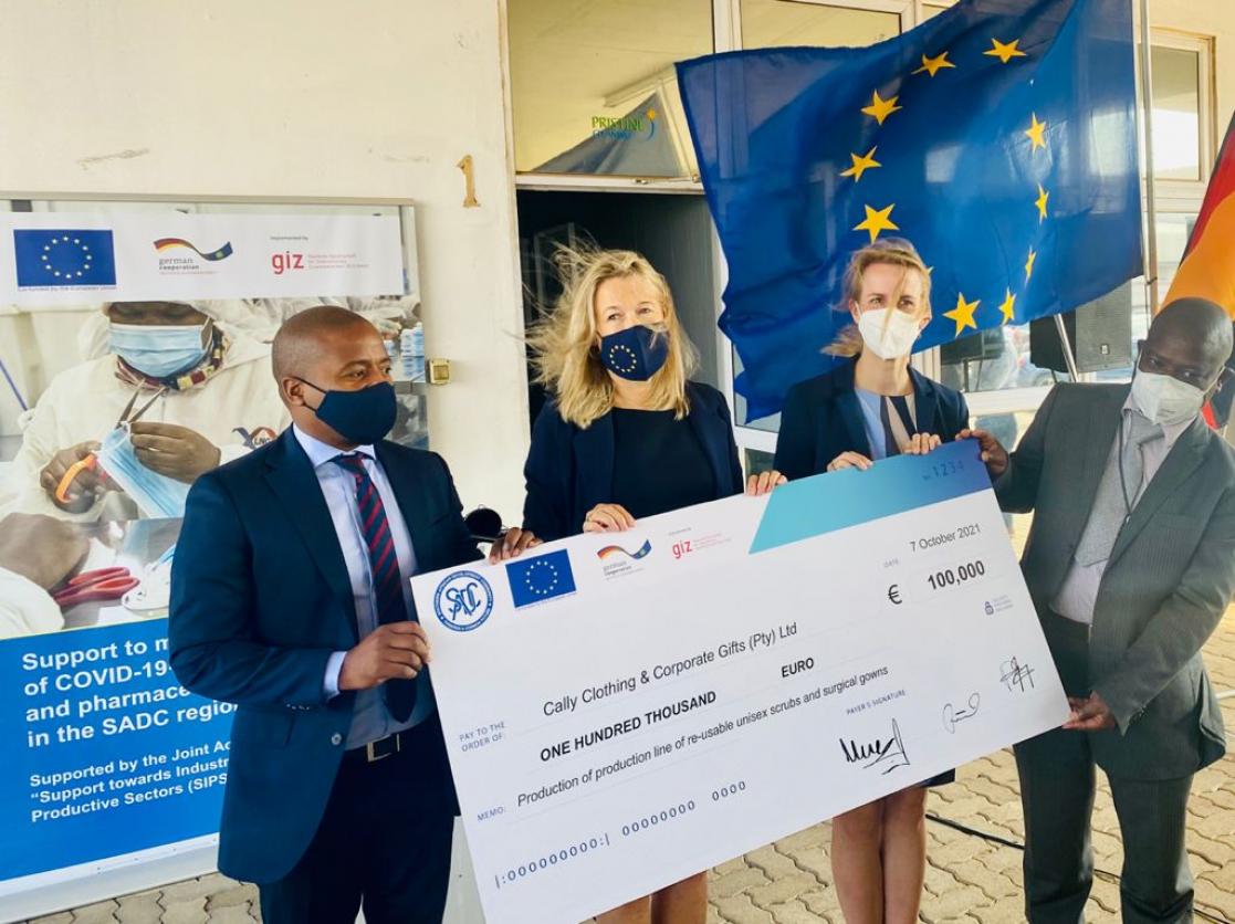 Two women and two men holding a cheque