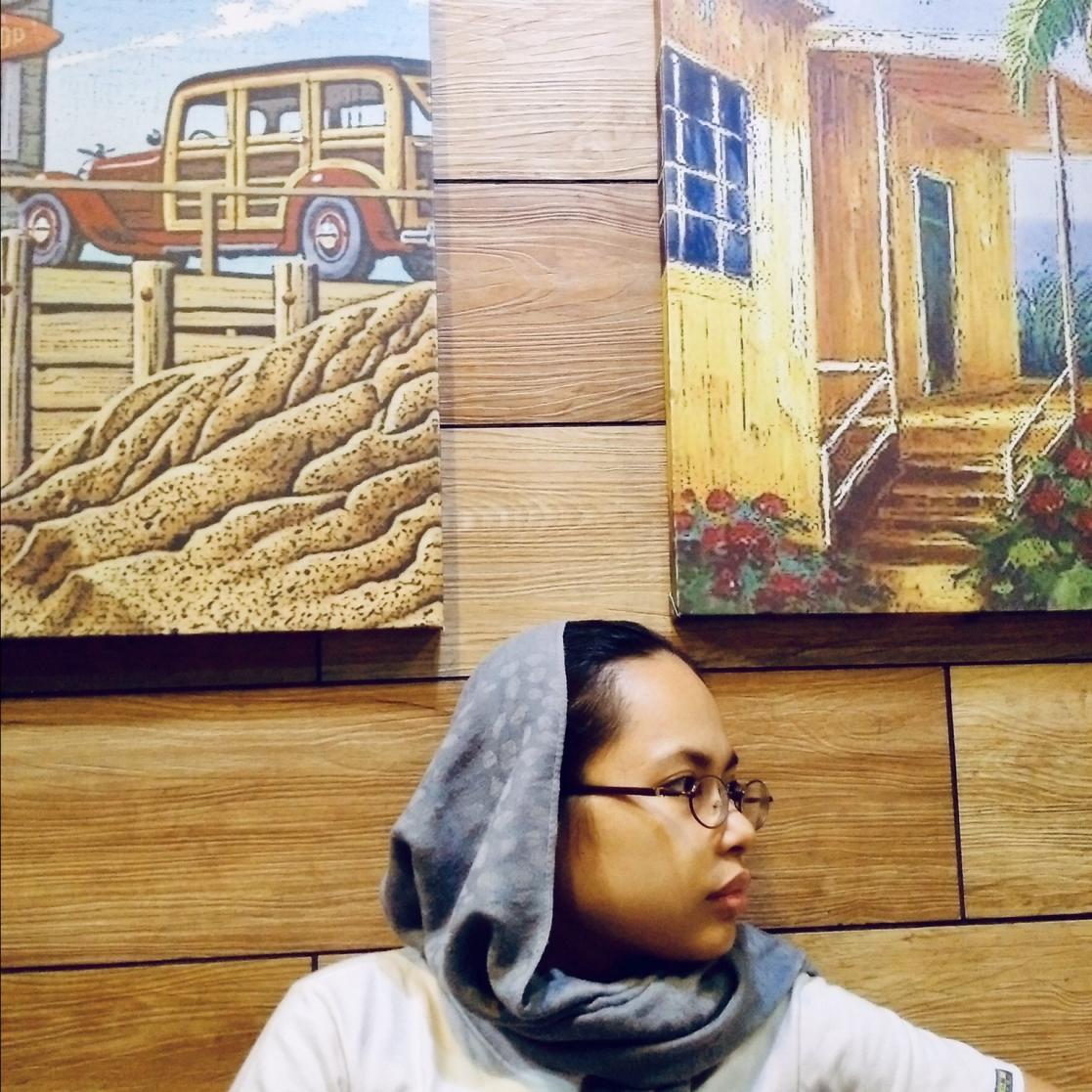 Woman sitting down in the middle of two pictures