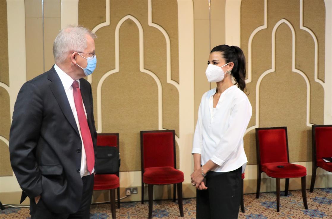Man in front of a woman, both wearing face masks
