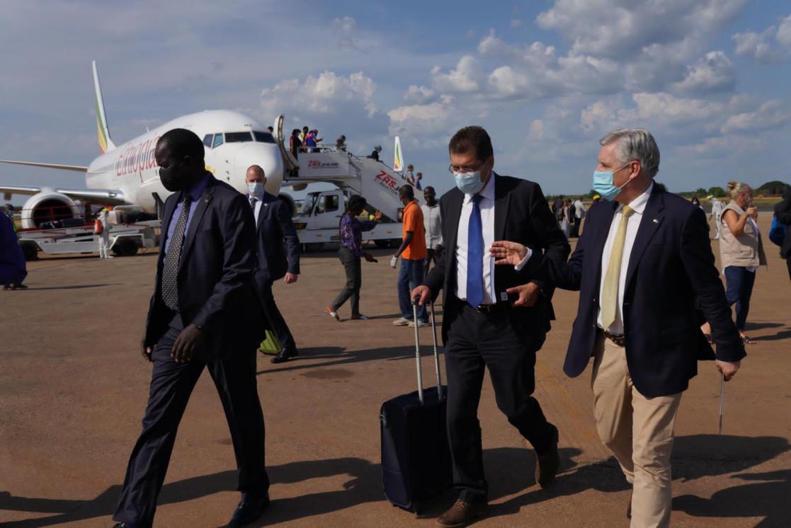 People walking down the runway after getting off an aircraft