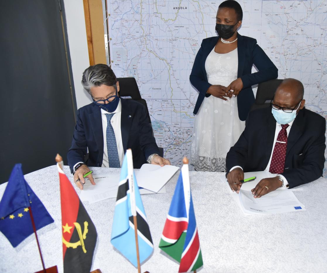 Two men signing documents