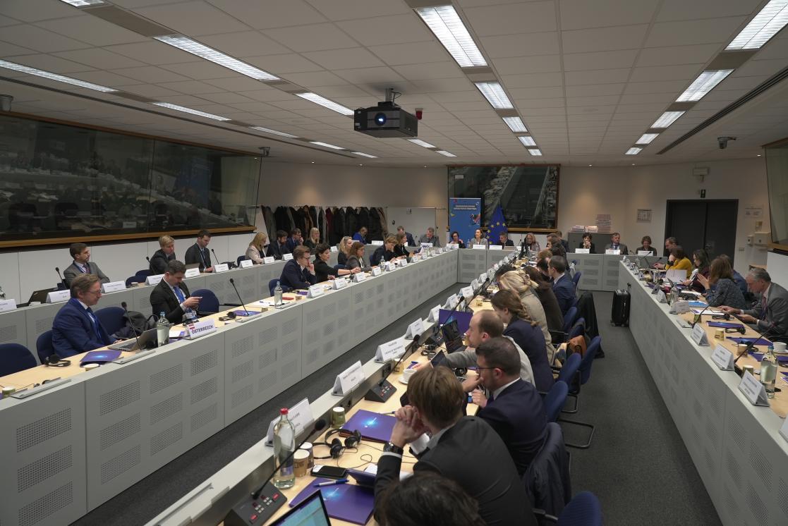 Picture of the meeting room with participants sitting on both sides of the table