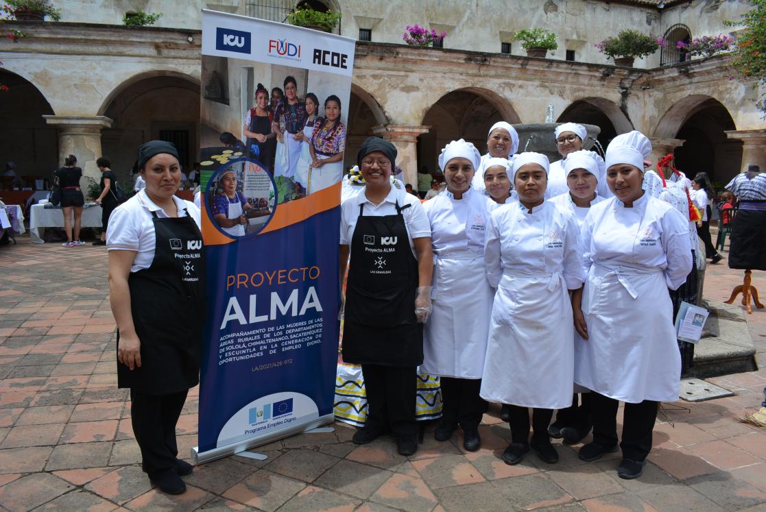 Grupo de estudiantes de distintas especialidades de cocina posan con banner del Proyecto ALMA.