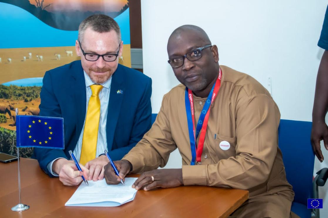 Ambassador Muller signing a grant contract with Action Aid SL Country Manager