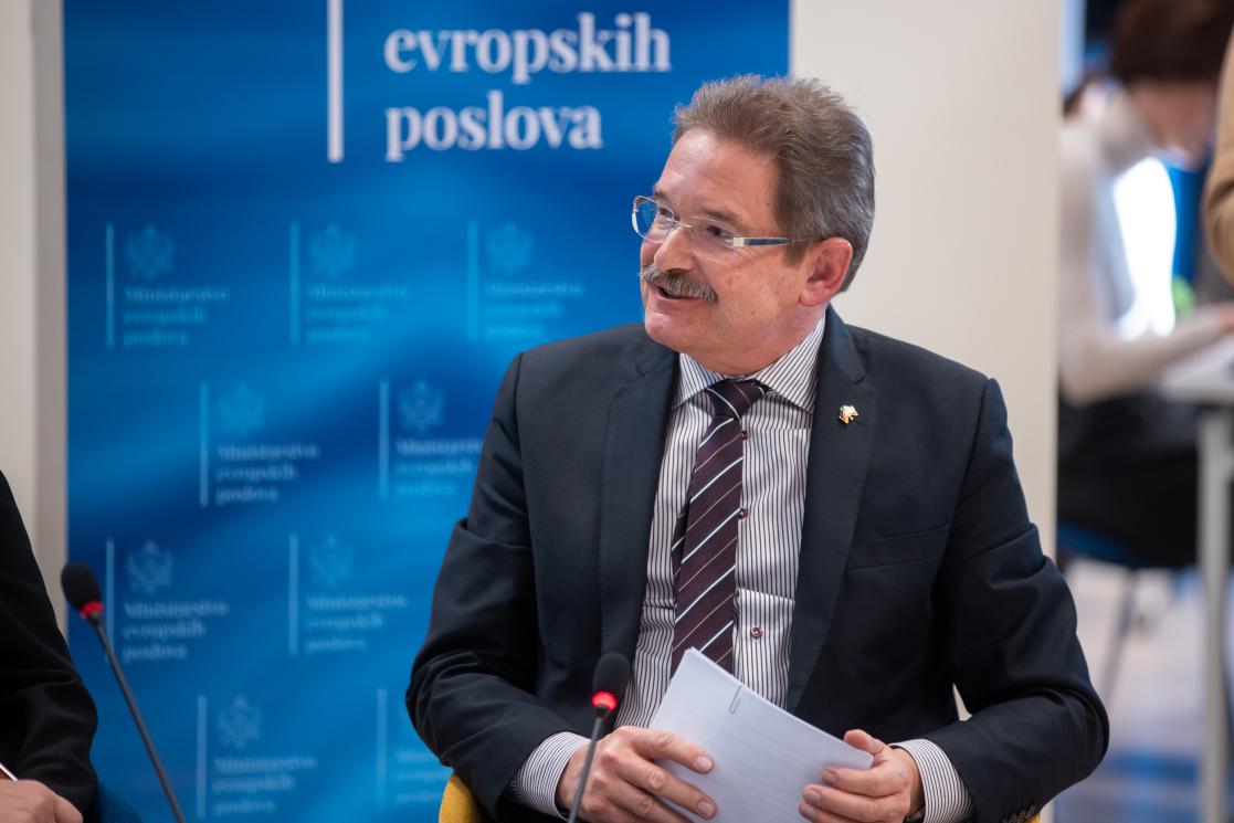 the Ambassador of Germany to montenegro sitting and holding a paper 
