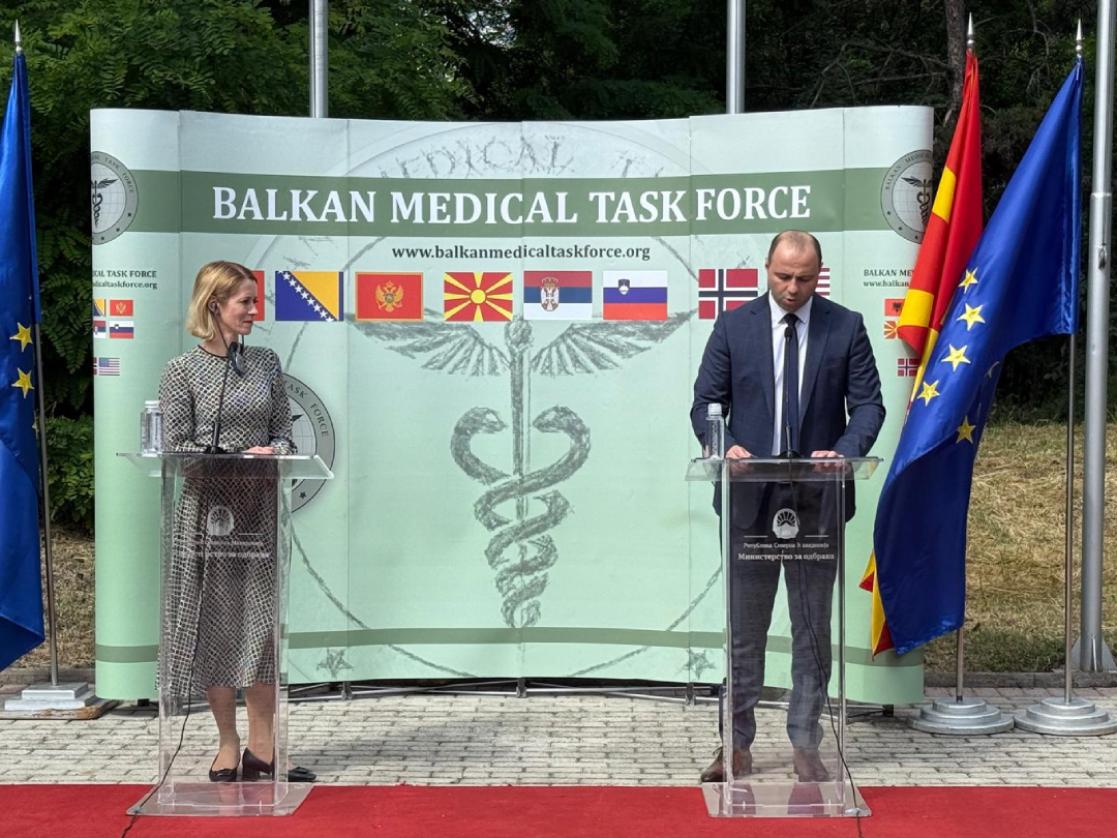 Woman and a man on stage at podiums, BMTF backdrop. 
