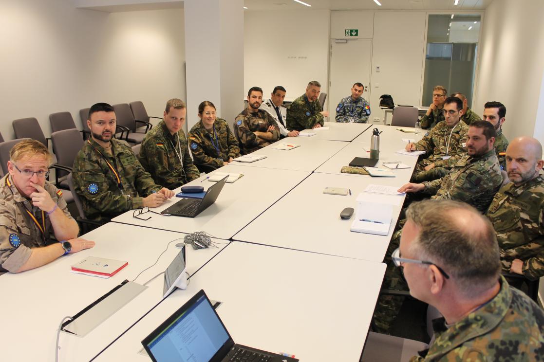 A group of military personnel at a table, planning. 