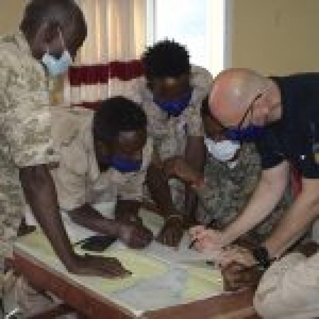 group of people looking into a map 