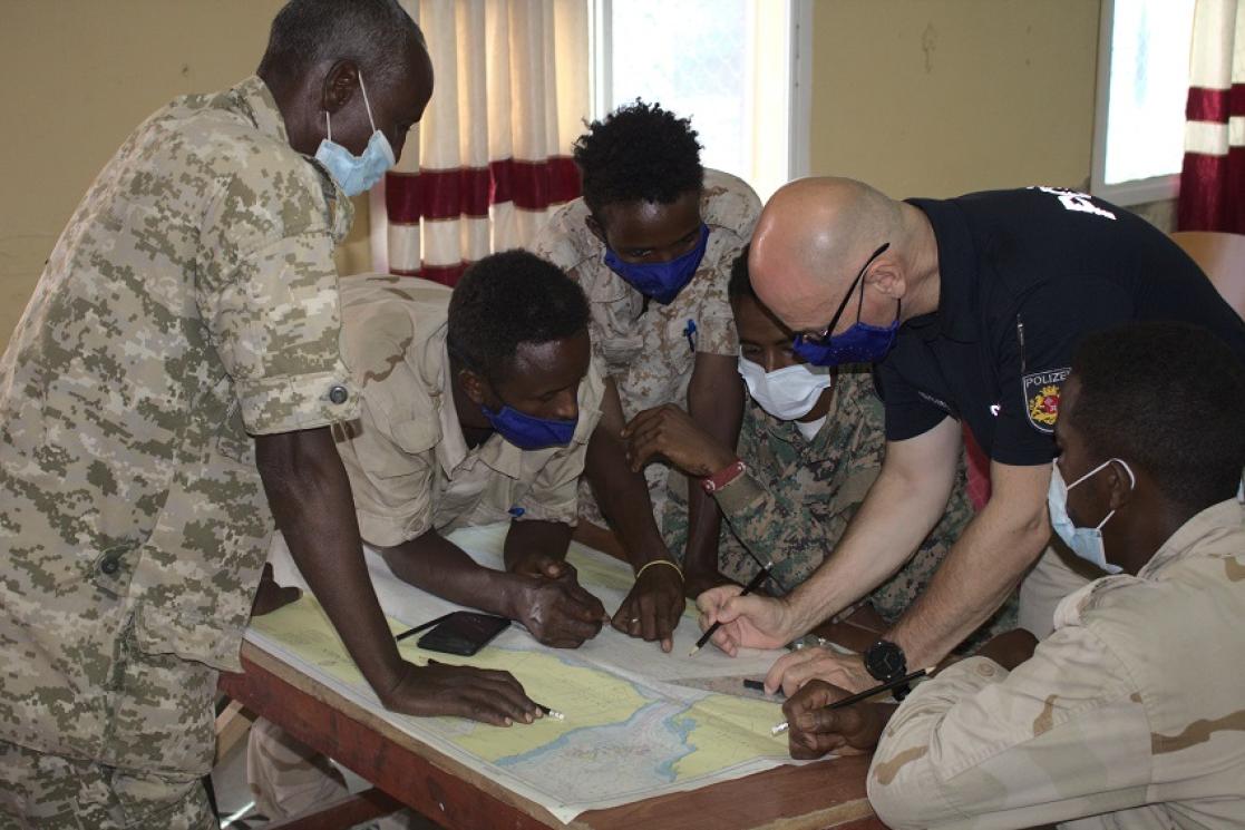 group of people looking into a map