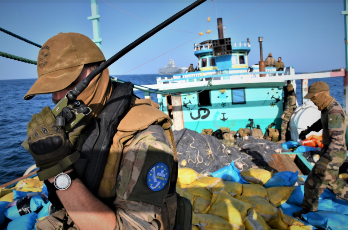 military person speaking on radio phone on a boat
