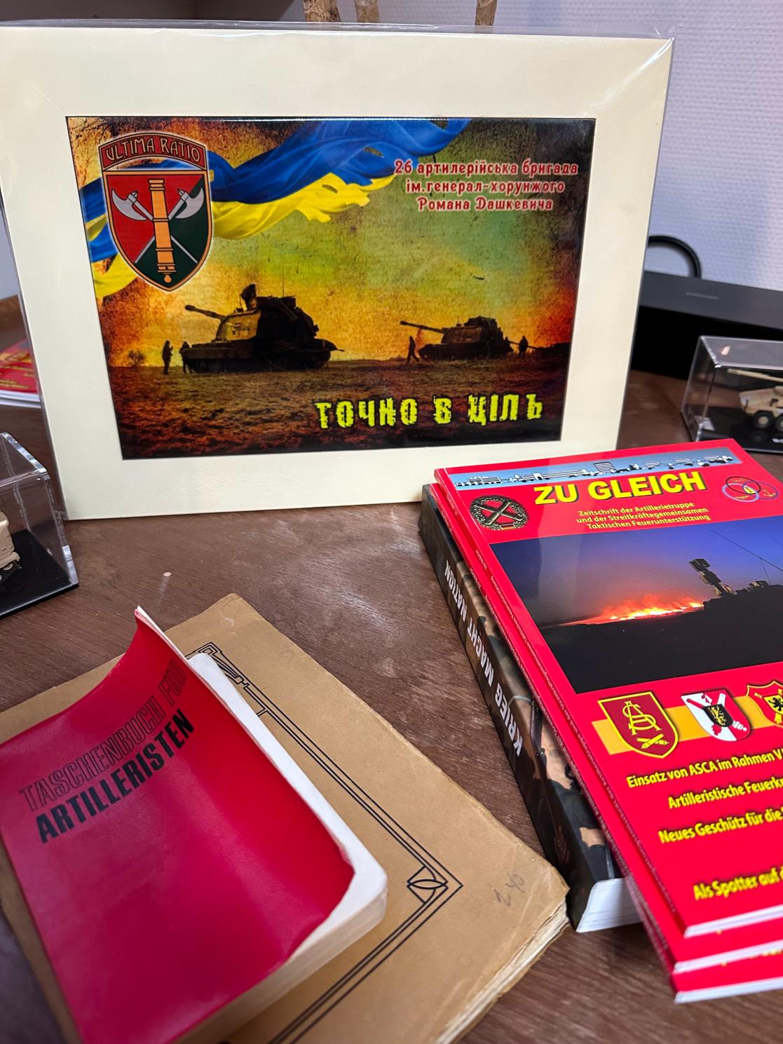 Books, photos, maps on a desk.