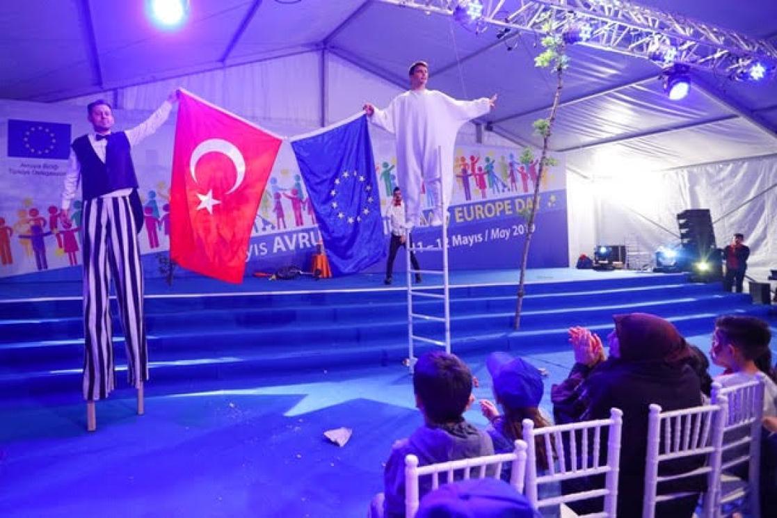 people on stilts showing flags ( Turkey and EU )