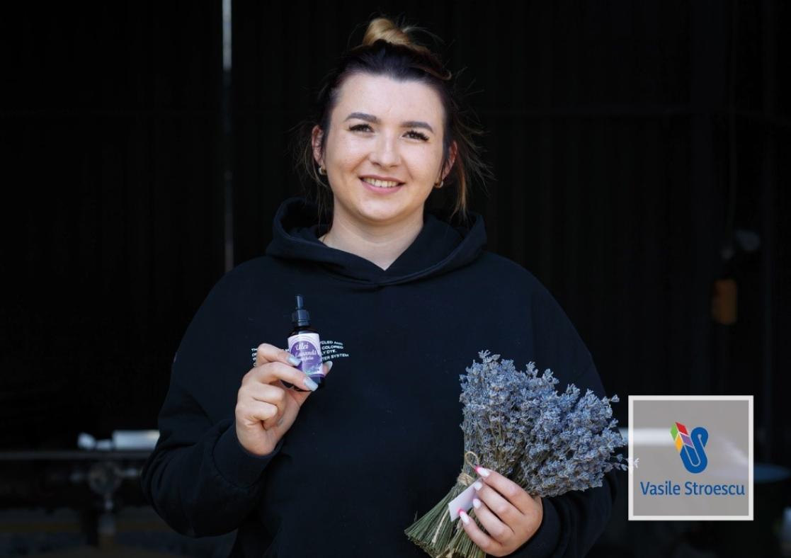woman artisan holding lavender oil product