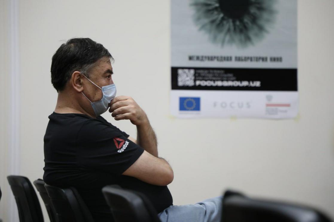 Man wearing a face mask sitting on a chair