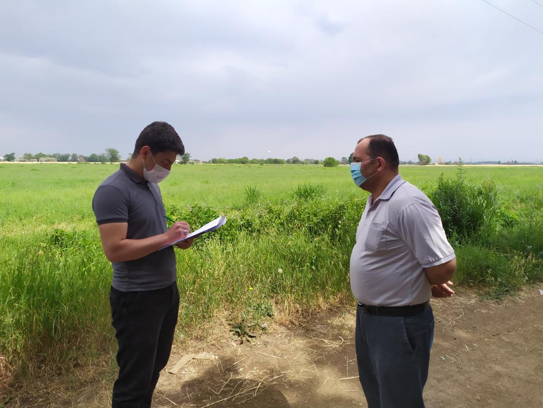 Two men talk while one of them takes notes