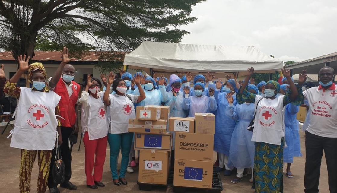 Group of people with their hands up posing next to cardboard boxes