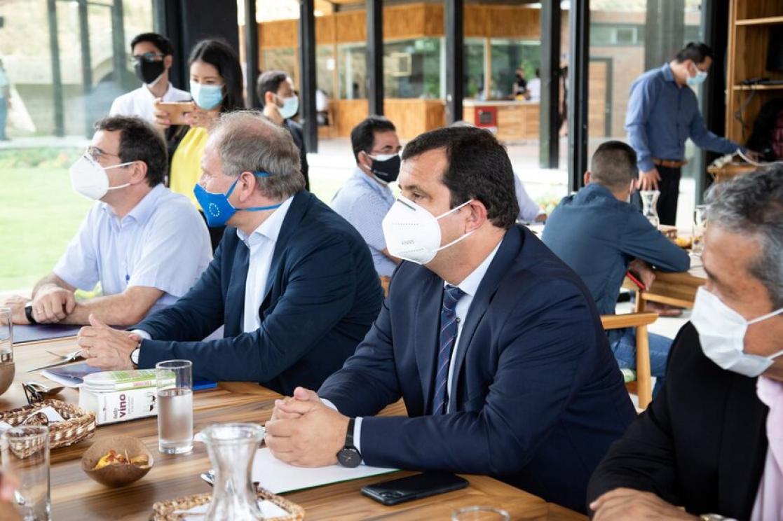 group of people in a desk in suits wearing a mask, having a reunion 