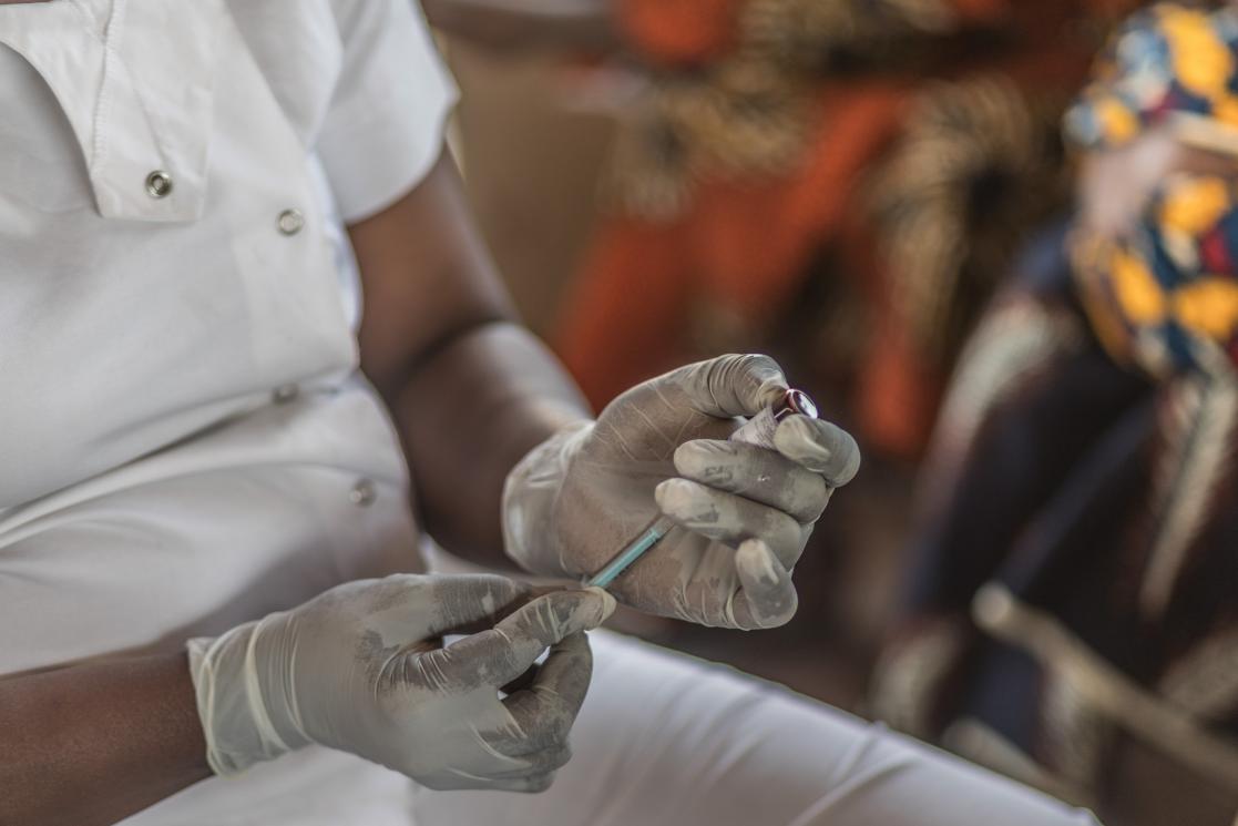 Gloved hands filling an injector 
