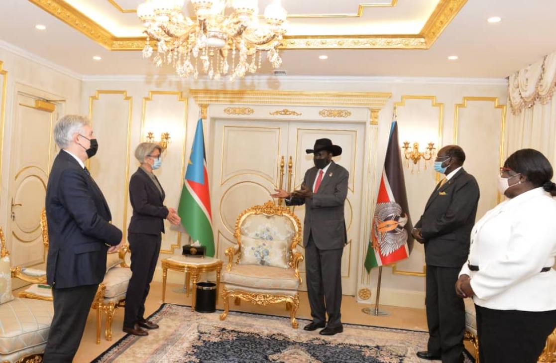 Two women and three men talking in a room