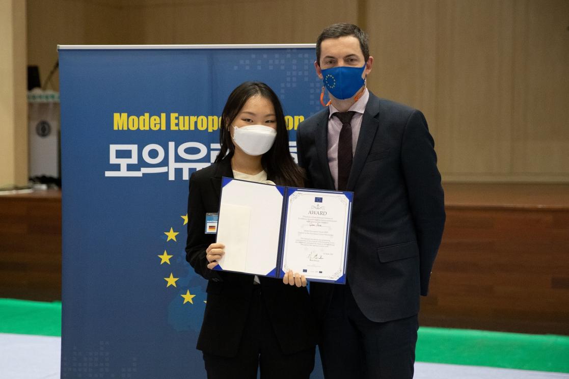 Man and woman posing, the woman with a diploma