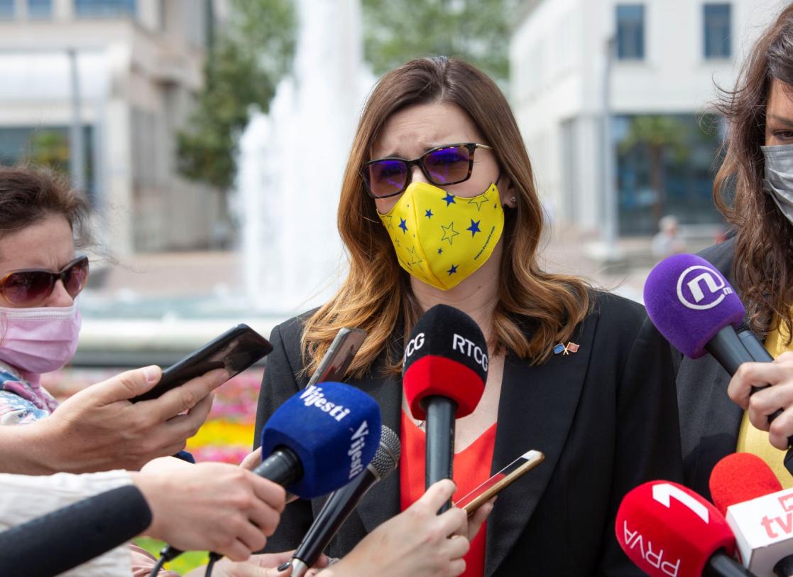 Woman wearing a mask speaking with the press