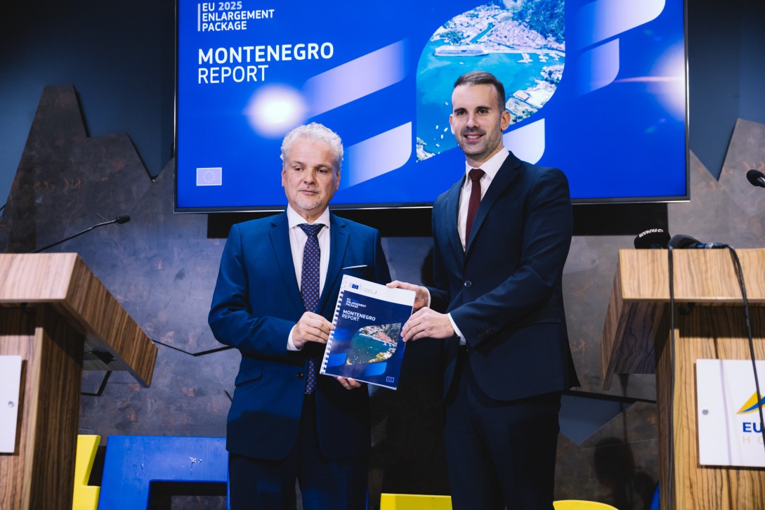 Ambassador Sattler and Prime Minister Spajić standing and holding the Montenegro Report 2025