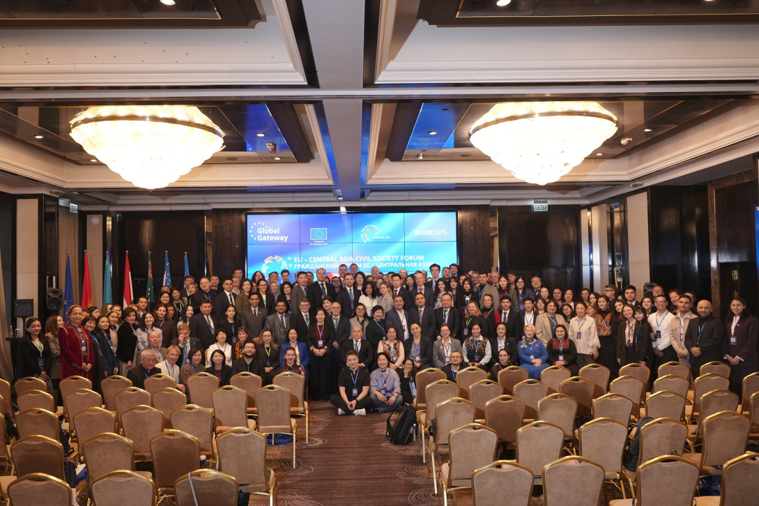 Group photo of a number of people in front of a LED screen