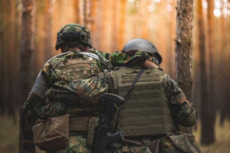 Two Ukrainian soldiers support one another during a training exercise.