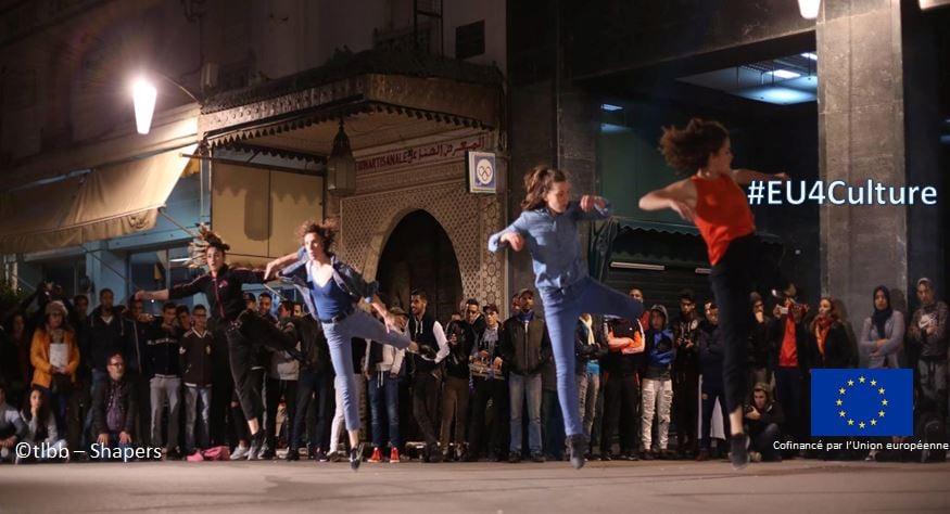 Des danseurs sur une place publique avec derrière eux des gens 