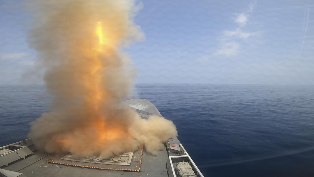 Missile launch plume from bow of a ship.