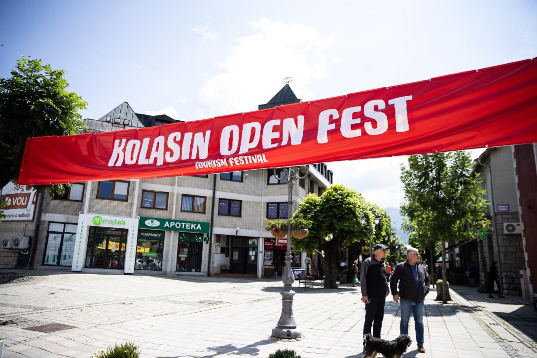 A large red banner strung across the open space between buildings that reads "KOLASIN OPEN FEST" 