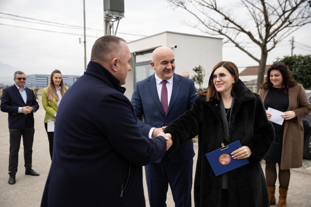 Minister of Agriculture Forestry and Water Management Joković standing by the Ambassador Oana Cristina Popa he is holding papers in one hand and with the other she shekes hands with IPARD II user Šahović
