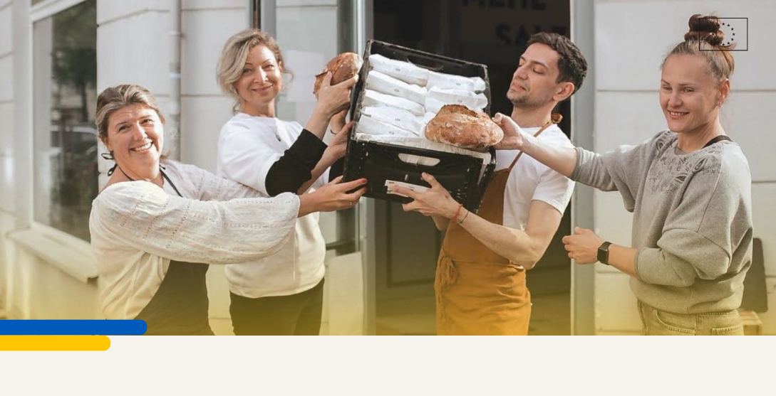 Picture of team of bakers holding a loaf of bread