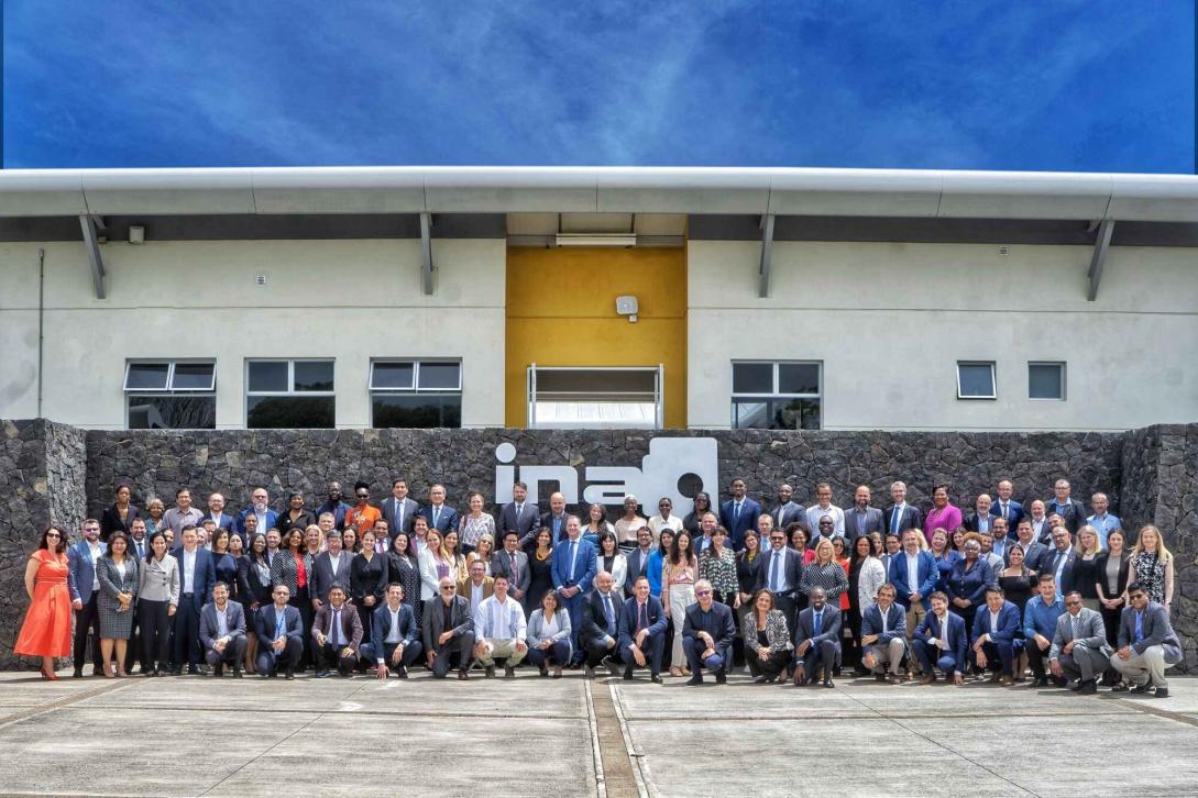 Group photo of around 100 delegates taken outside.