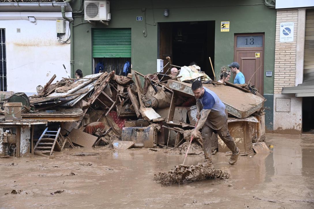 A man cleaning the mud during the flood