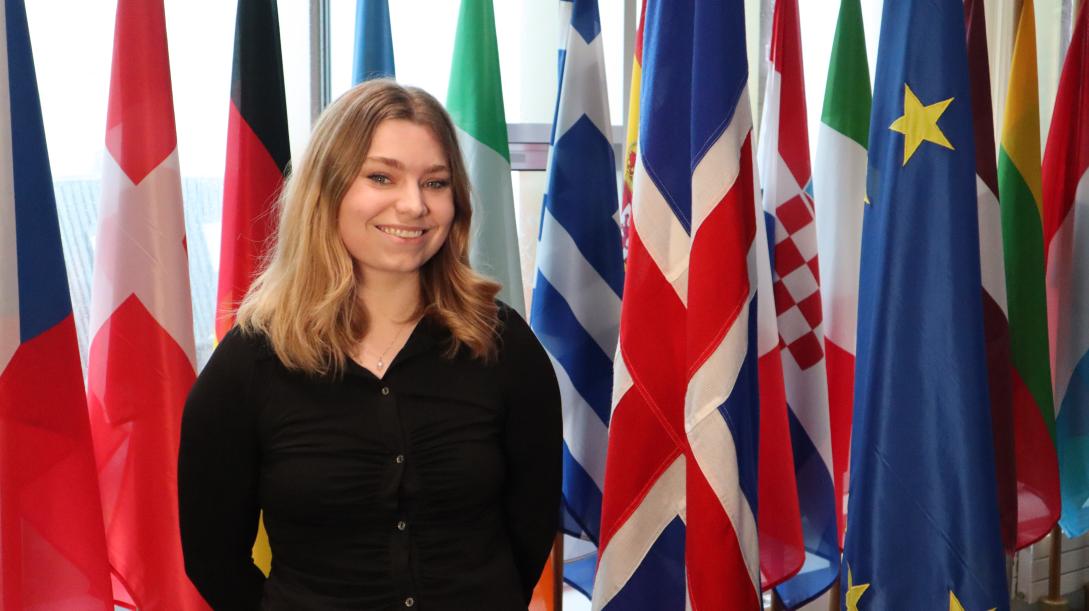 picture of a woman standing next to flags
