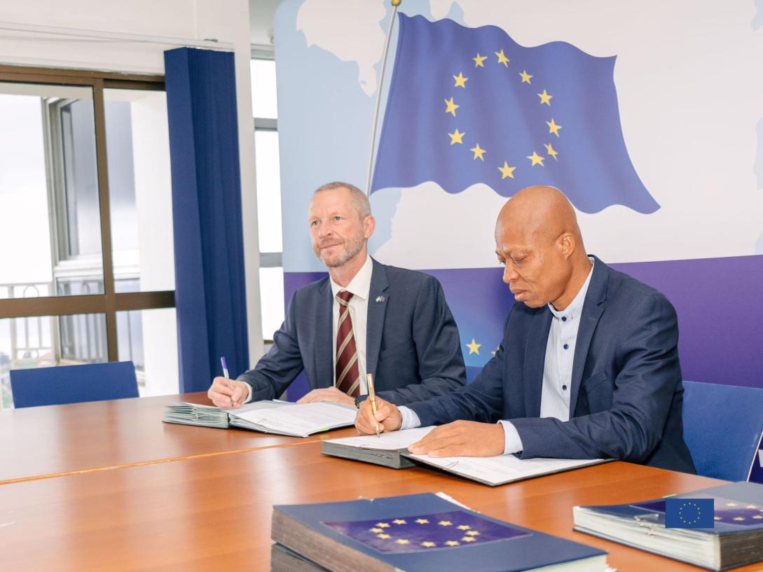EU Delegation Head of Cooperation signining the agreement with a represenative of an NGO