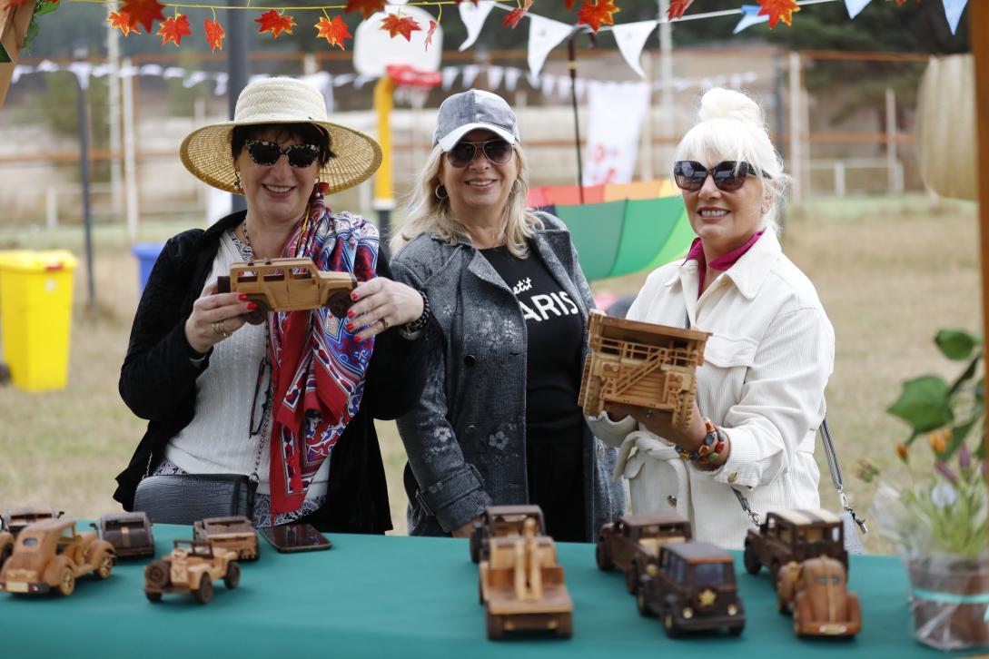Three women with wooden crafts