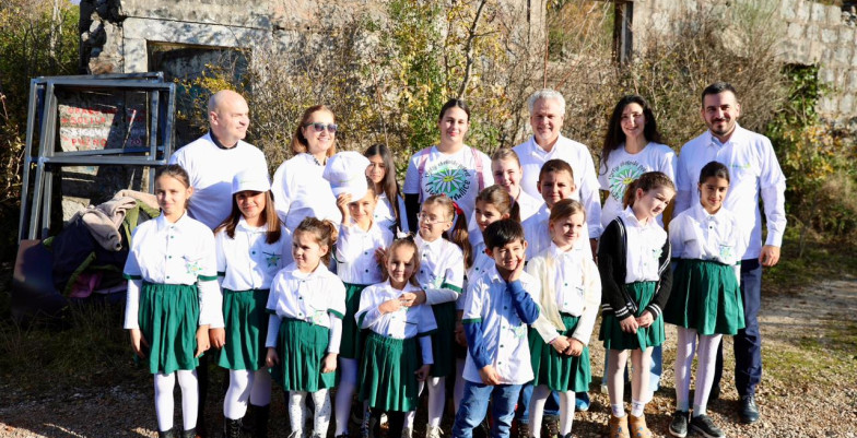 Ambassador Sattler standing with the group of people and children