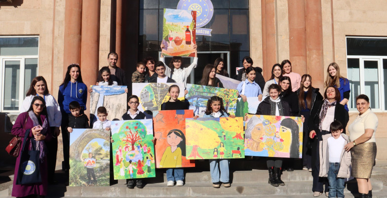 Young artists holding their artworks for EUMA's photo exhibition "What Equality Looks Like"