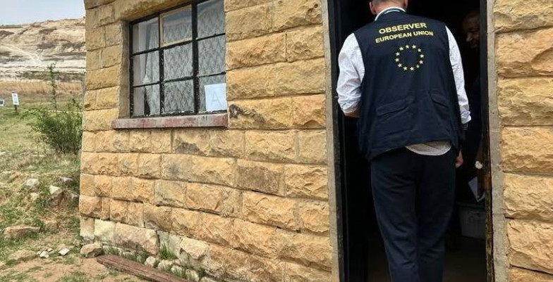 EU Election observer entering stone house in Hololo or Motete in Lesotho