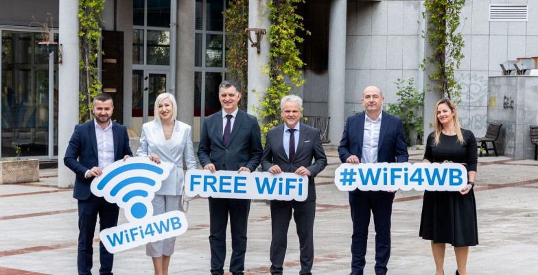 Officials standing and holding signs (WiFi4WB; FreeWiFi